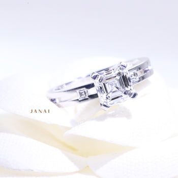 A 18ct white gold asscher cut diamond solitaire engagement ring with two carre cut diamonds on the band