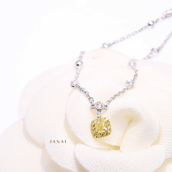 An 18ct white gold fancy cushion yellow diamond bracelet with surrounding round brilliant cut diamonds 