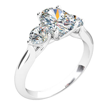 A platinum or white gold oval cut diamond solitaire trilogy engagement ring with two round brilliant cut diamonds