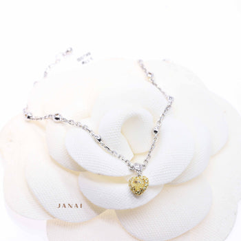 An 18ct white gold fancy heart-shaped yellow diamond bracelet with surrounding round brilliant cut diamonds