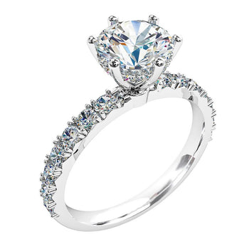 A platinum or white gold round brilliant cut diamond solitaire with diamonds on the band engagement ring and a hidden halo