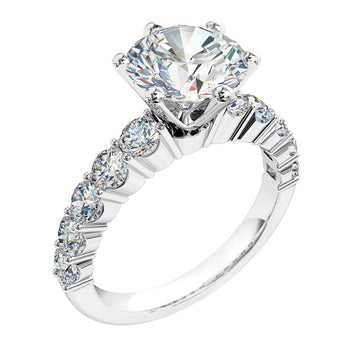 A platinum or white gold round cut diamond solitaire engagement ring with a diamond band