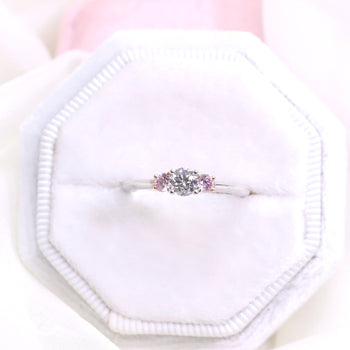 A beautiful trilogy engagement ring featuring argyle certified natural pink diamonds and a round brilliant cut diamond