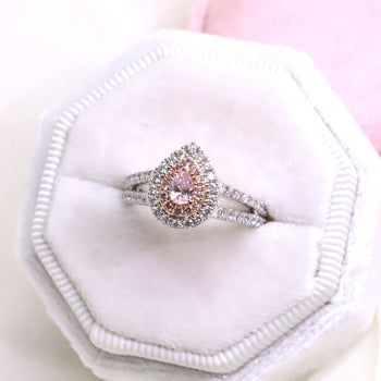 An 18ct white gold argyle certified pear-shaped natural pink diamond set in a double halo engagement ring featuring round brilliant cut diamonds on a split diamond band
