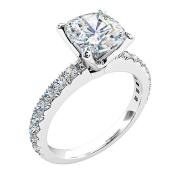A platinum or white gold cushion cut diamond solitaire with side stones engagement ring