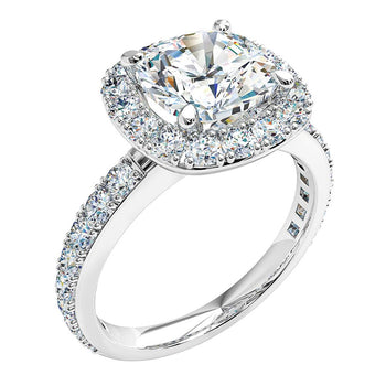 A platinum or white gold cushion halo engagement ring with diamonds on the band