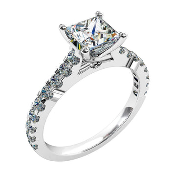A platinum or white gold princess cut diamond solitaire engagement ring featuring round brilliant cut diamonds on the band in a shared claw setting