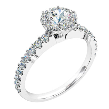 A platinum or white gold round brilliant cut diamond illusion halo engagement ring with diamonds along the band