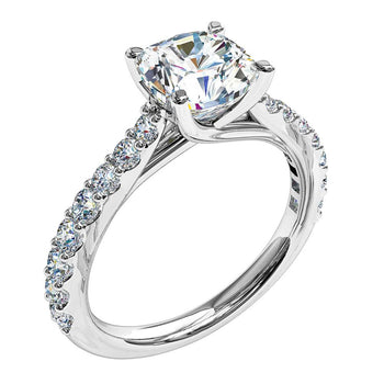 A platinum or white gold cushion cut diamonds solitaire engagement ring with diamonds on the band in a shared claw setting
