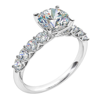 A platinum or white gold round brilliant cut diamond solitaire engagement ring featuring a shared claw diamond band