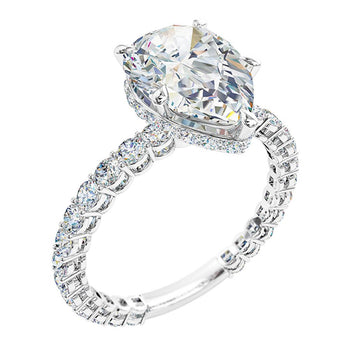 A platinum or white gold pear shaped diamond solitaire engagement ring with diamonds on the band and a hidden halo