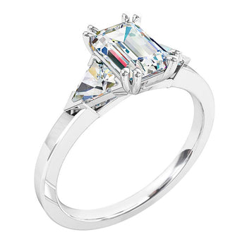 A platinum or white gold emerald cut diamond trilogy solitaire engagement ring. Complimented with two trilliant cut diamonds