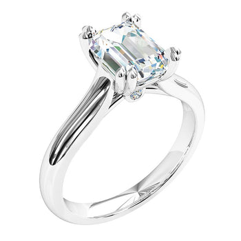 A platinum or white gold emerald cut diamond solitaire double claw engagement ring. Complimented by a round cut diamond under the coronet