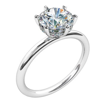 A platinum or white gold round brilliant cut diamond six claw solitaire engagement ring with a diamond hidden halo 