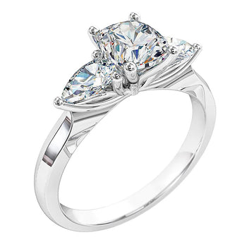 A platinum or white gold cushion cut diamond trilogy solitaire engagement ring with two matching pear shaped diamonds