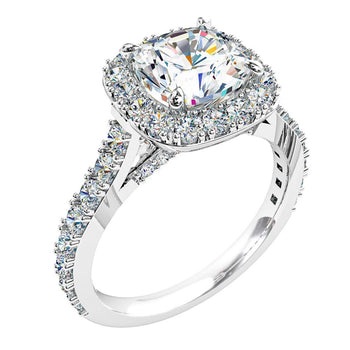 A platinum or white gold cushion cut diamond halo engagement ring with diamonds on the band and under the bridge