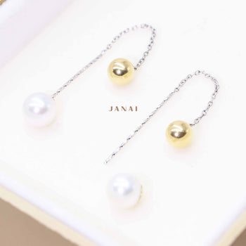 A matching pair of dangling pearl earrings in 18ct white and yellow gold